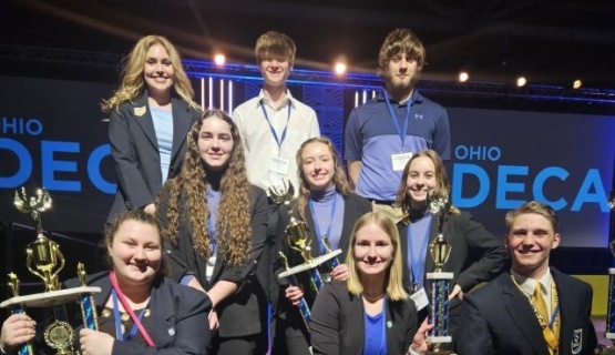 St. Marys DECA students pose with their winning trophies. 