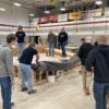 Students preparing to add a roll of roofing material to their roof mock-up.: Gallery Image 1 