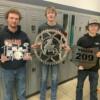 Three students showing their plasma cut welding projects. 