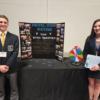 Two DECA students pose with a presentation board.: Gallery Image 1 