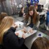 Senior Early Childhood student helps a sophomore with her cinnamon dough ornament.: Gallery Image 1 