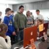8th graders listen as Interactive Media students explain how they use their computer software.: Gallery Image 1 