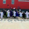 Early Childhood students celebrate graduation by jumping and throwing their motarboards (graduation cap) in the air.: Gallery Image 1 
