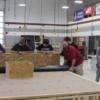 Construction students learn and participate in a lesson in commercial roofing with a Cotterman representative. 