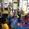 Teacher education student leading preschoolers in a song. 