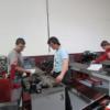 Junior auto tech students study and work with small engines. 