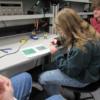 A Sophomore works on a circuit under the watchful eye of a REC Tech senior.: Gallery Image 3 