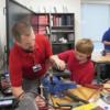 Auto Tech Instructor Brian Hess helps a sophomore test his project to see if it runs.: Gallery Image 1 