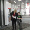 A mother and her son stop to study a clue to try to figure out where to go next.: Gallery Image 1 