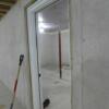 Unfinished basement with safe room, utilities and shelving, egress window, and staircase to garage.: Gallery Image 4 