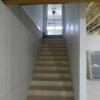 Unfinished basement with safe room, utilities and shelving, egress window, and staircase to garage.: Gallery Image 2 