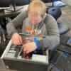 Student working on the guts of a computer. 