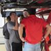 Minster students check out the underside of a vehicle in auto tech: Gallery Image 1 