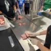Students getting hands on in the meat processing lesson.: Gallery Image 2 