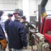 Joe Braun, welding instructor (far right handling equipment) explains/demonstrates a welding process to a class of adults. 