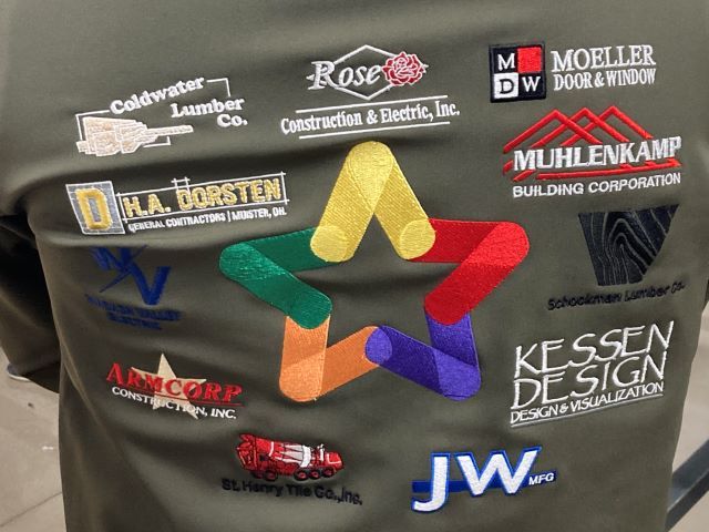 Names of companies are embroidered on a jacket that they purchased for construction students.: Featured Image 1 