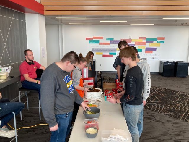Career Pathway students dish out toppings as Tri Star students fill their walking taco bag.: Featured Image 1 