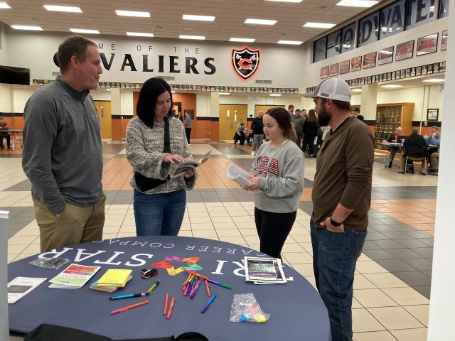 Tim Buschur is pictured with a student and her parents at the Tri Star table at Coldwater's High School Scheduling Night.: Featured Image 1 
